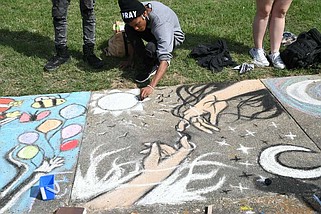 A student at Hot Springs World Class High School works on "Endless Battle," created in May 2021 as part of Chalk Walk during Arts & The Park. (The Sentinel-Record/File photo)